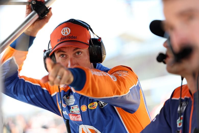 Joey Logano looks on and points.