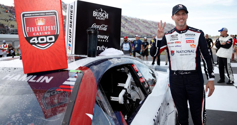Denny Hamlin poses for a photo in Victory Lane at Michigan International Speedway.
