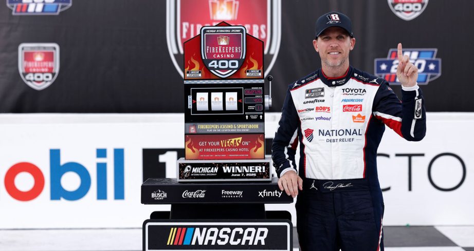 Denny Hamlin poses for a photo in Victory Lane following his NASCAR Cup Series win at Michigan International Speedway.
