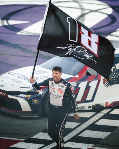 Denny Hamlin waves Kyle Busch tribute flag.