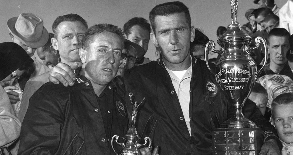 Former NASCAR champion Rex White celebrates a North Wilkesboro Speedway victory with crew chief Lewis Clements in 1961.