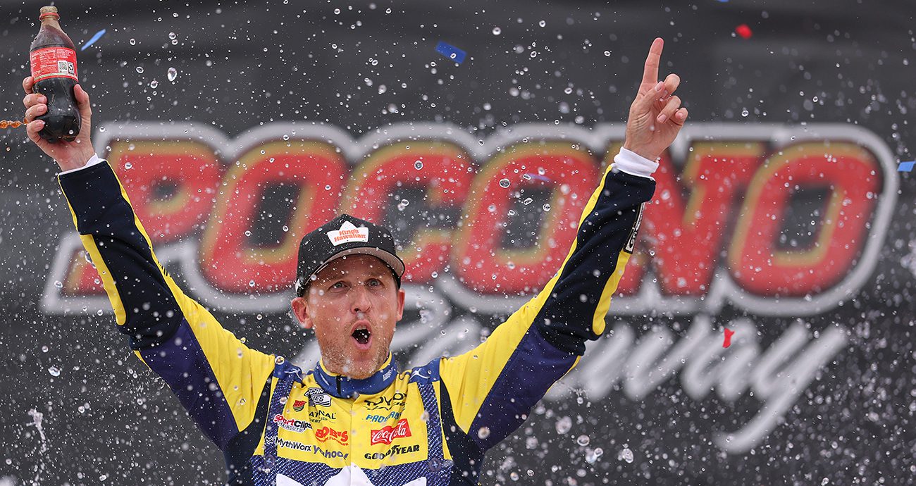 Denny Hamlin, driver of the #11 King's Hawaiian Shake 'Em Bites Toyota, celebrates in victory lane after winning the NASCAR Cup Series Great American Getaway 400 presented by VISITPA at Pocono Raceway on June 14, 2026 in Long Pond, Pennsylvania.