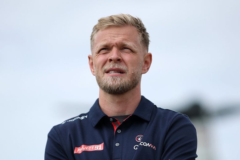 Kevin Magnussen looks on.