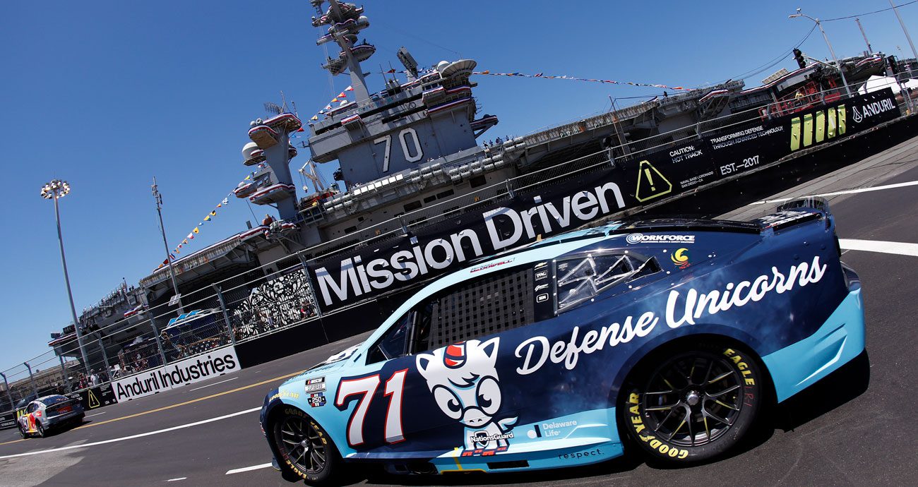 Michael McDowell follows Shane van Gisbergen at Naval Base Coronado in the NASCAR Cup Series past USS Carl Vinson.
