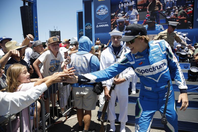 Carson Hocevar high fives a fan.