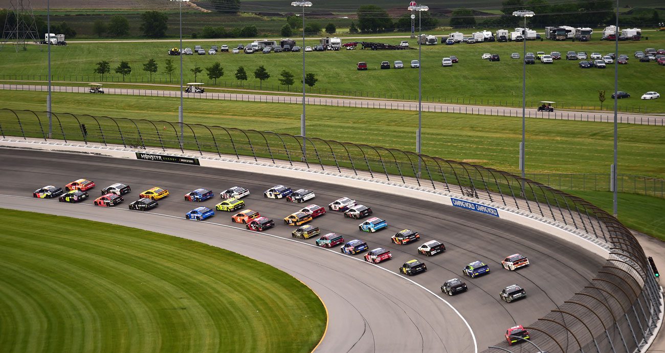 NASCAR Cup Series cars race through a turn at Chicagoland Speedway.