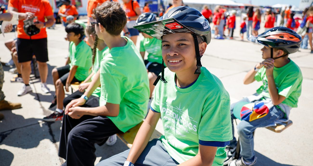 Kid wearing bike helmet give out at The NASCAR Foundation's Speediatrics Fun Day Festival at Naval Base Coronado.