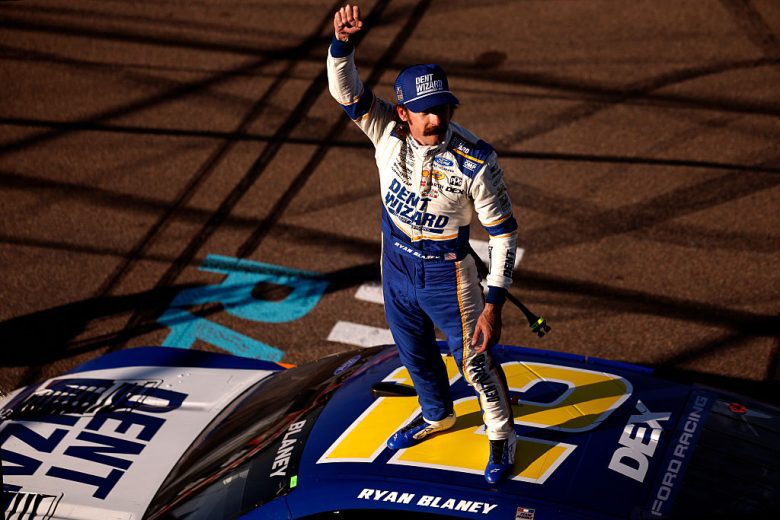 Ryan Blaney points to the crowd while standing atop his No. 12 Team Penske Ford.