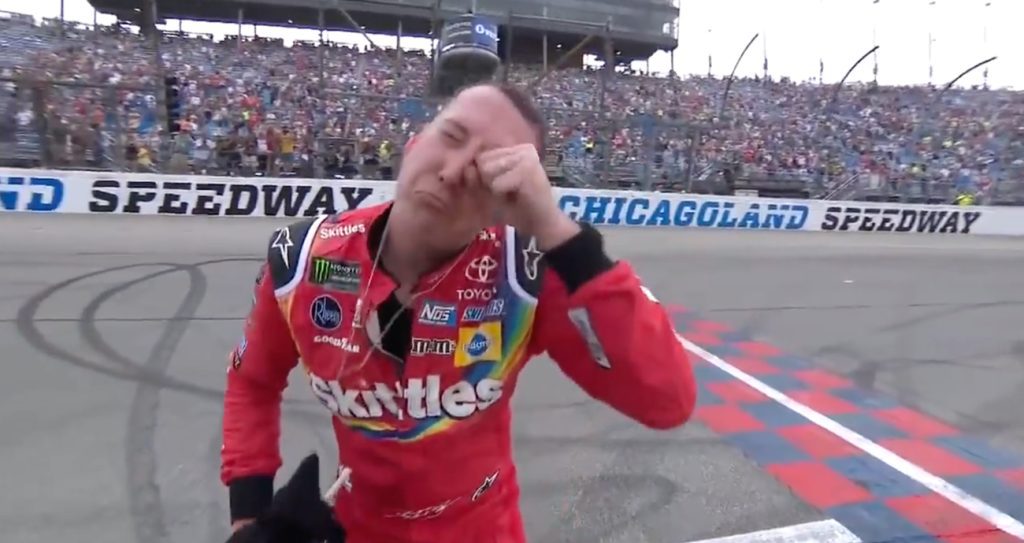 Kyle Busch pretends to wipe tears from eyes after winning the NASCAR Cup Series race in 2018 at Chicagoland Speedway.