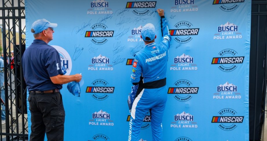 Denny Hamlin signs the board after winning the Chicagoland Speedway pole.