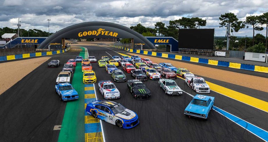 A selection of vintage stock cars from Historic Sportscar Racing line up for a group photo at the Le Mans Classic Legend at Circuit de la Sarthe.