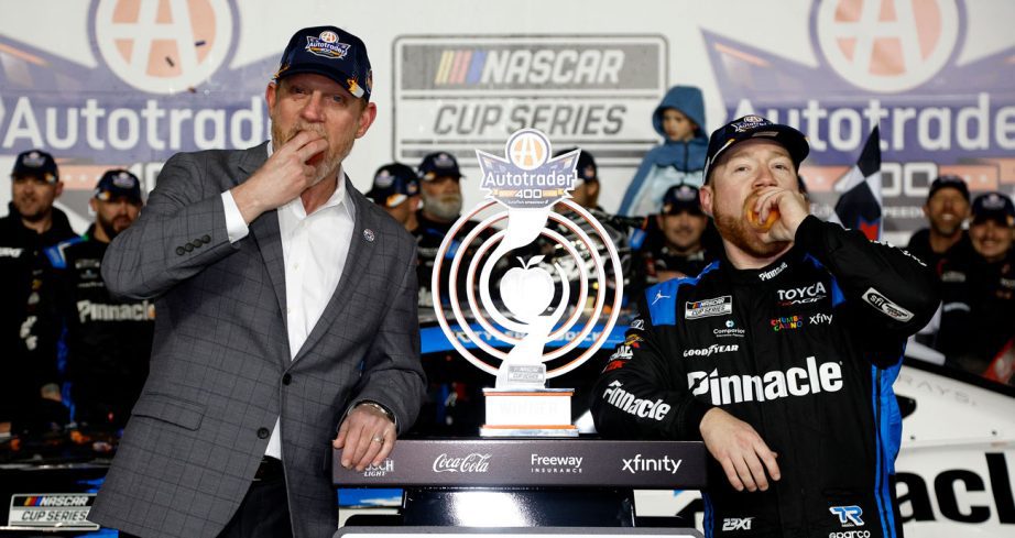 Tyler Reddick (R) eats a peach in Victory Lane at EchoPark Speedway.
