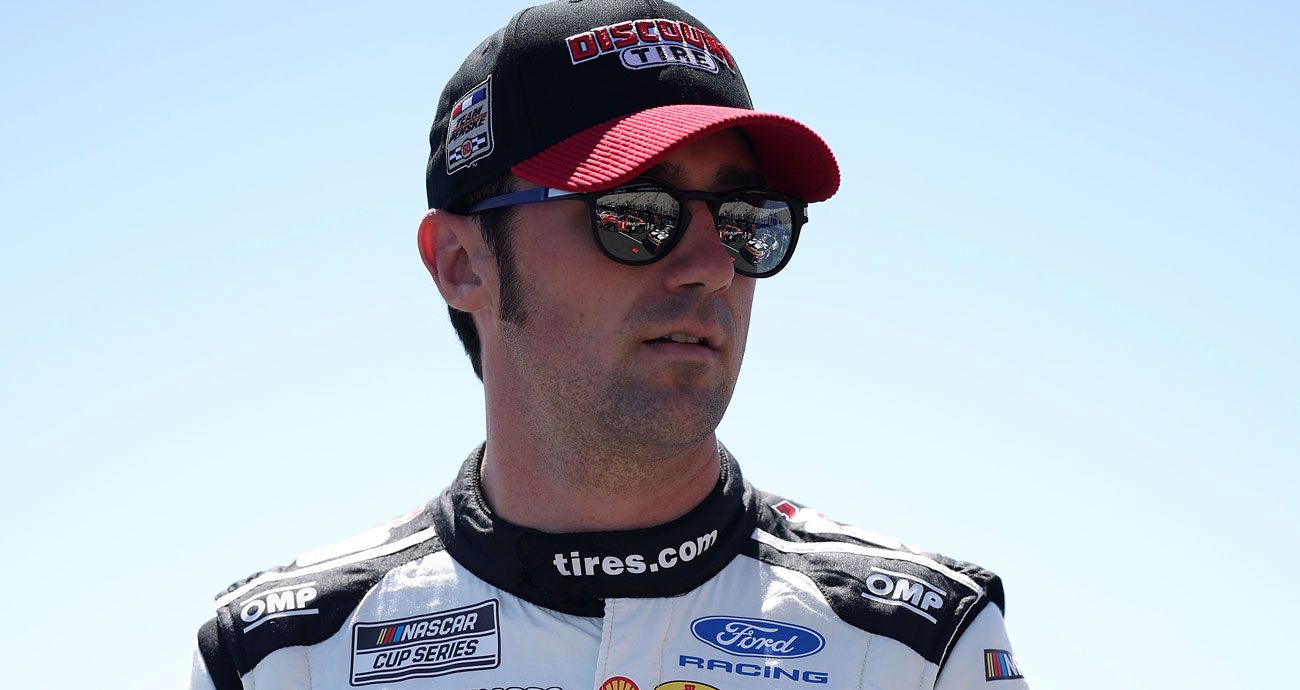 Austin Cindric, driver of the No. 2 Team Penske Ford, looks on ahead of a NASCAR Cup Series race.