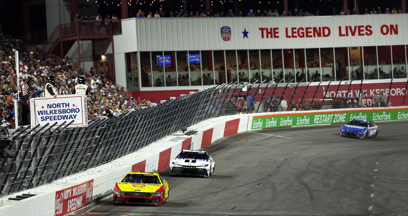 NASCAR Cup Series cars race at North Wilkesboro Speedway.