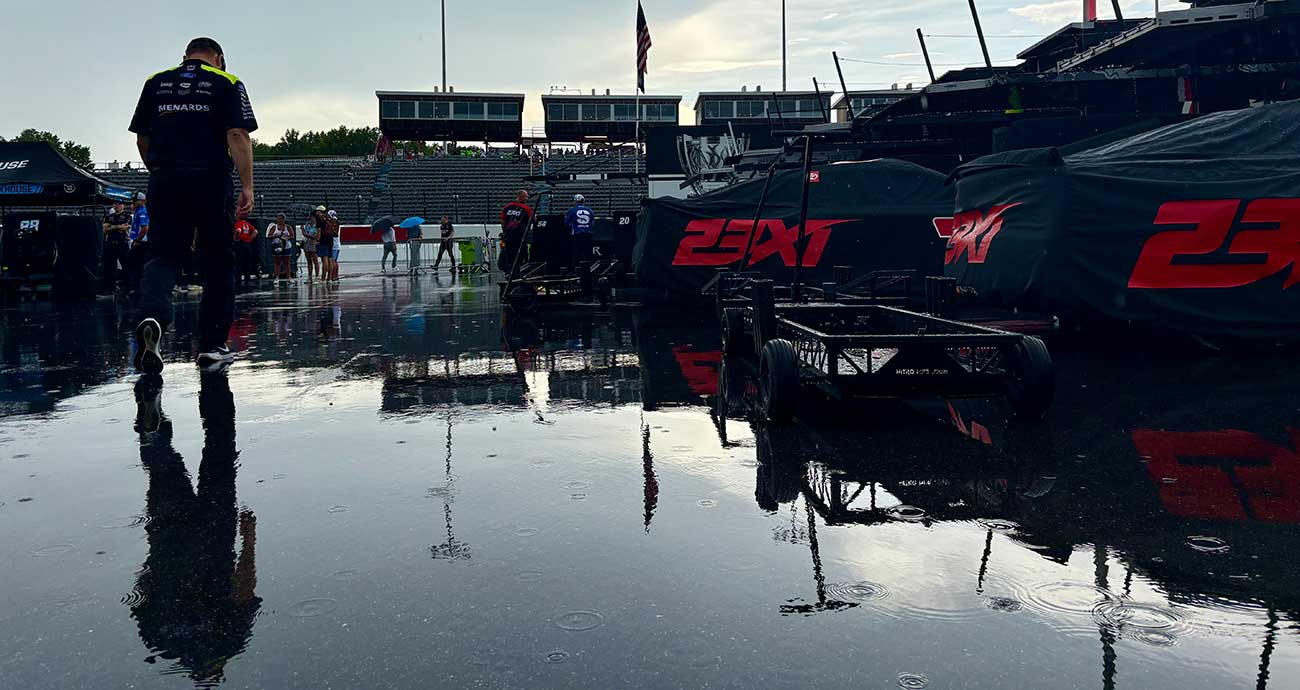 A Team Penske crew member walks through the puddles in the Cup Series garage at North Wilkesboro Speedway