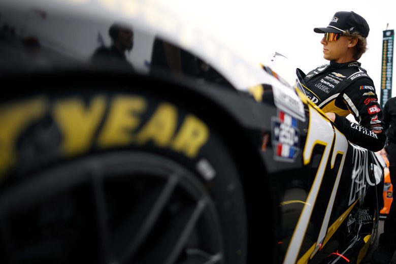 Carson Hocevar enters his car at Indianapolis.