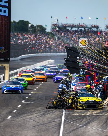 NASCAR Cup Series cars get tended to on pit road at Indianapolis Motor Speedway.