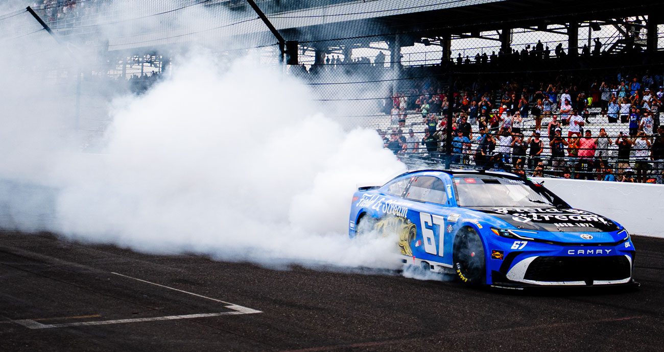 Corey Heim performs a burnout after winning the Brickyard 400.