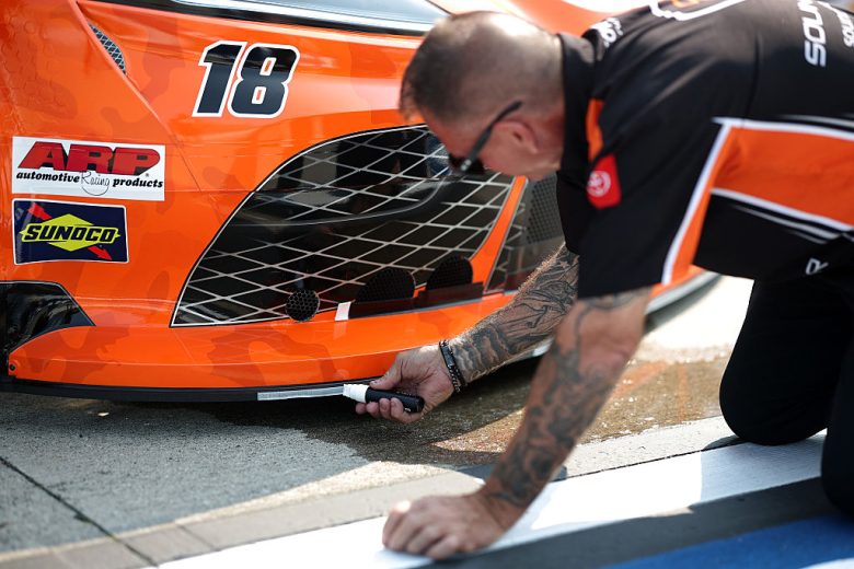 A crew member checks a car.