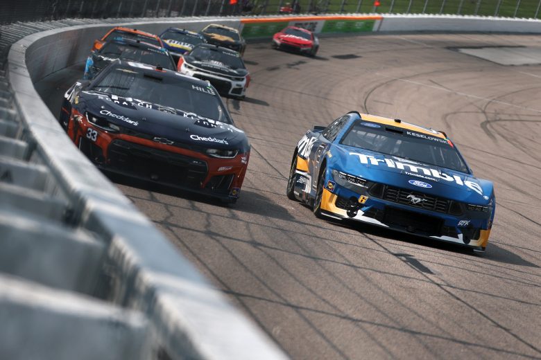 Cup Series cars race each other at Iowa Speedway.