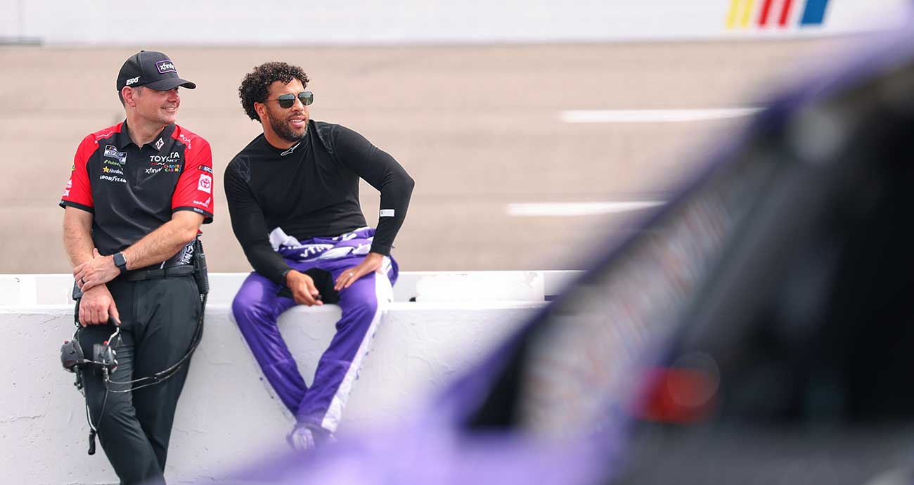 Bubba Wallace, right, and No. 23 crew chief Charles Denike chat as they lean on the pit wall before Cup Series qualifying at Richmond Raceway