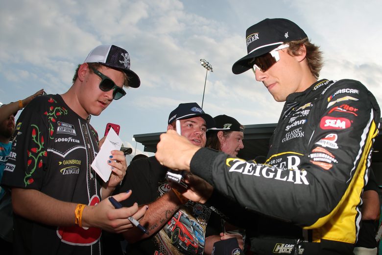 Carson Hocevar signs autographs for fans on the red carpet at Richmond.