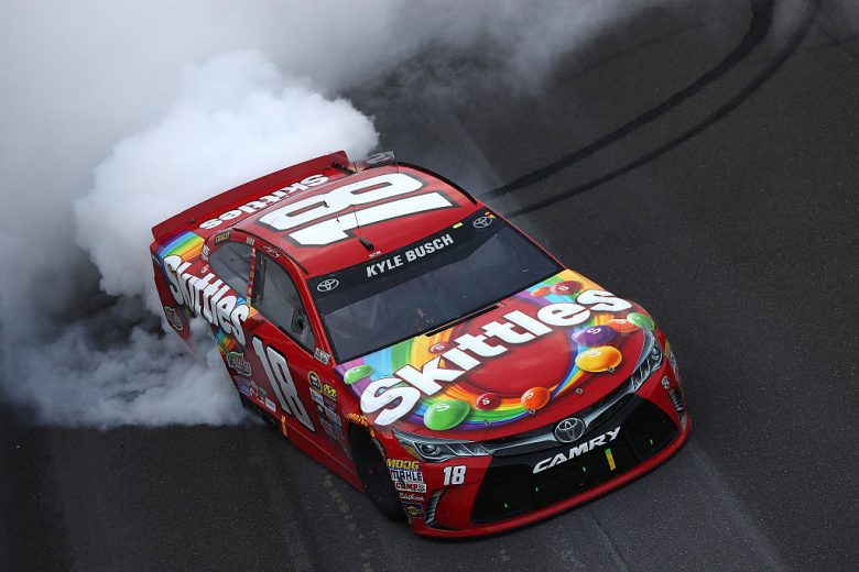 The No. 18 Joe Gibbs Racing Toyota does a celebratory burnout at Indianapolis Motor Speedway.