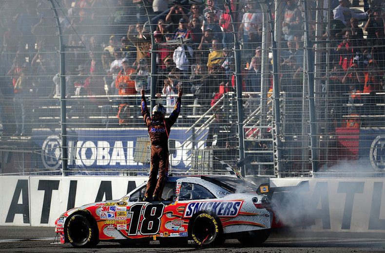 Kyle Busch celebrates atop his No. 18 Joe Gibbs Racing Toyota at EchoPark Speedway.