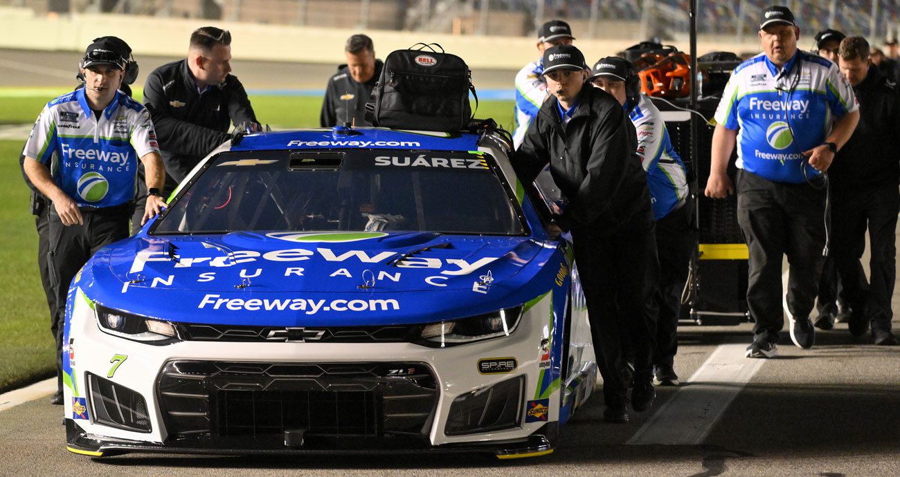 The No. 7 Spire Motorsports group pushes the car for Daniel Suárez on pit road at Daytona.