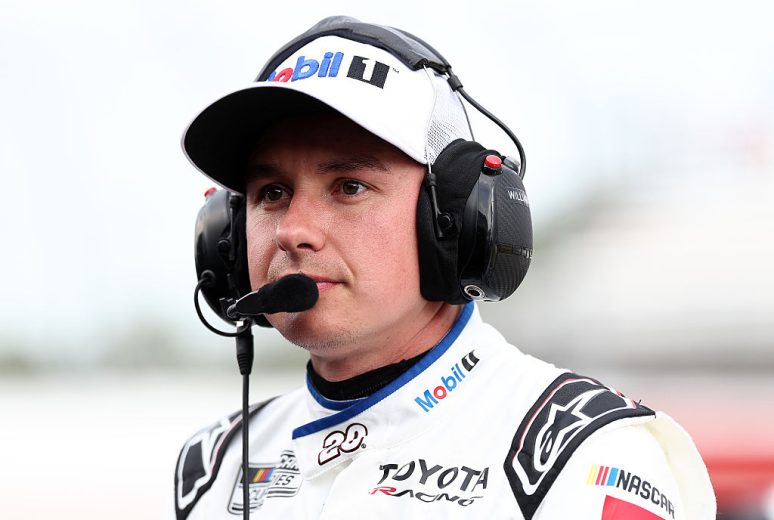 Christopher Bell looks on.