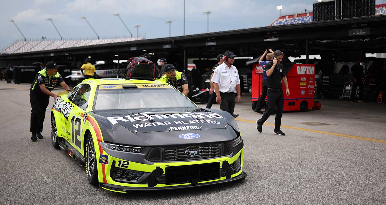 The Team Penske crew pushes the No. 12 Ford through the Cup Series garage at Darlington Raceway