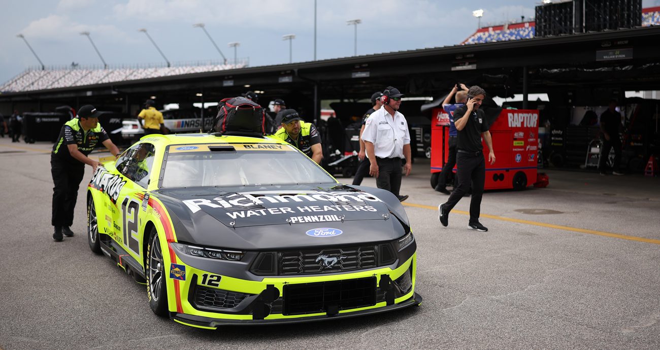 Crew members roll Ryan Blaney's No. 12 Ford through the garage area at Darlington Raceway.