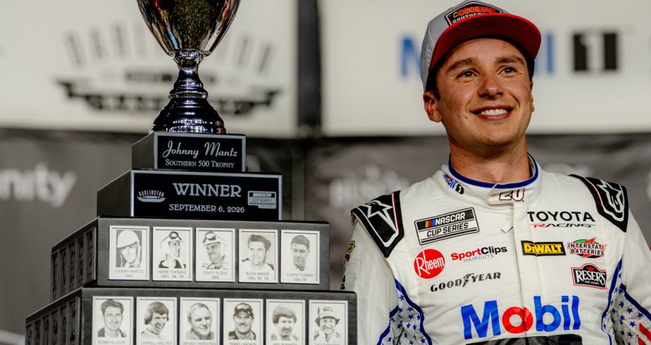 Christopher Bell smiles while standing next to the Johnny Mantz Southern 500 Trophy on Sept. 6, 2026 at Darlington Raceway.
