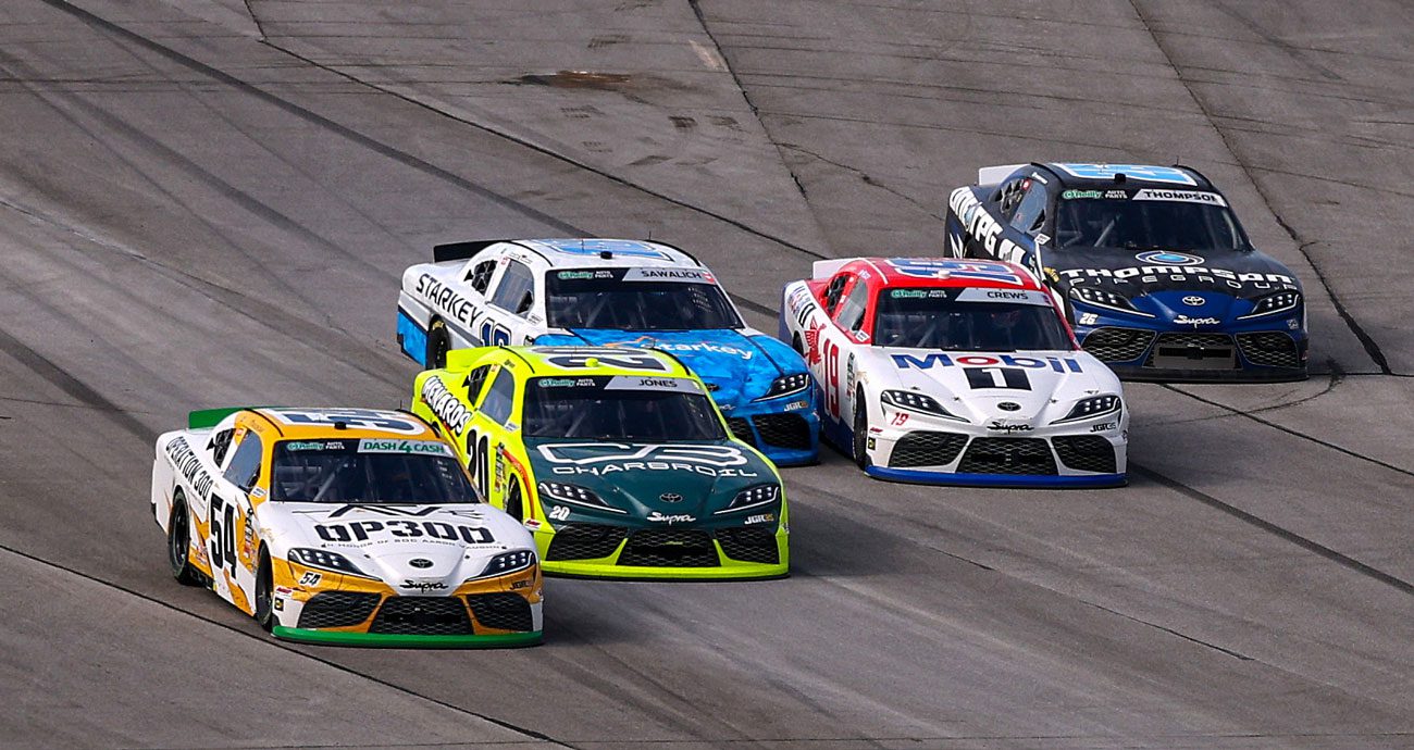 Joe Gibbs Racing Cars race toward pit road at Talladega Superspeedway.