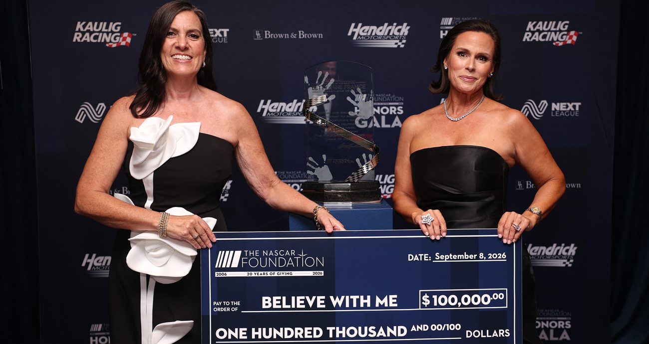 Nichole Krieger, VP and Executive Director of The NASCAR Foundation, presents Lyette Reback, Reback, founder and volunteer of Believe With Me, with the check for winning the 2026 Betty Jane France Humanitarian Award.