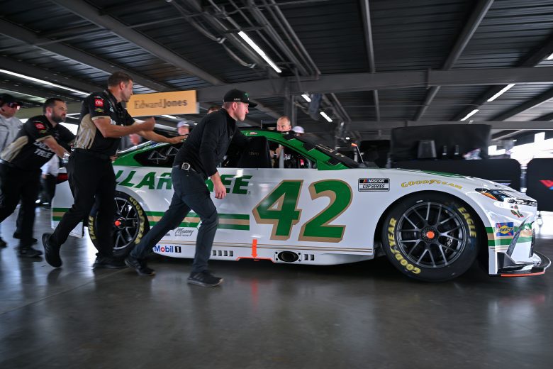 Legacy motor club team pushes car to grid.
