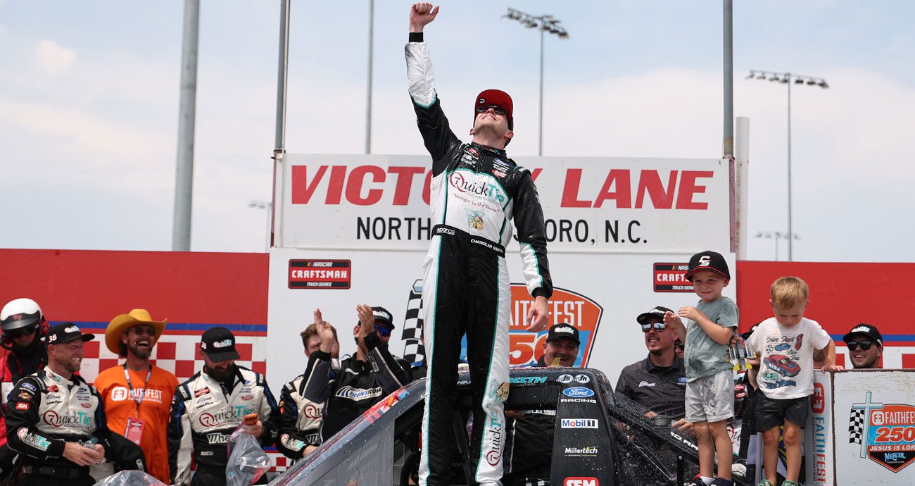 Chandler Smith raises his hand toward the sky at North Wilkesboro Speedway.