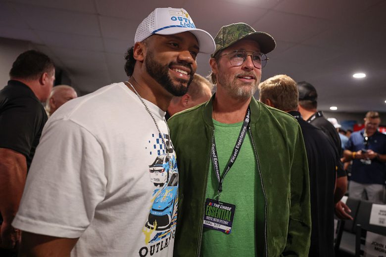 Russell Wilson and Brad Pitt pose for a photo.