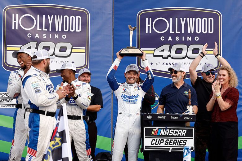 Kyle Larson hoists the victory trophy at Kansas Speedway.