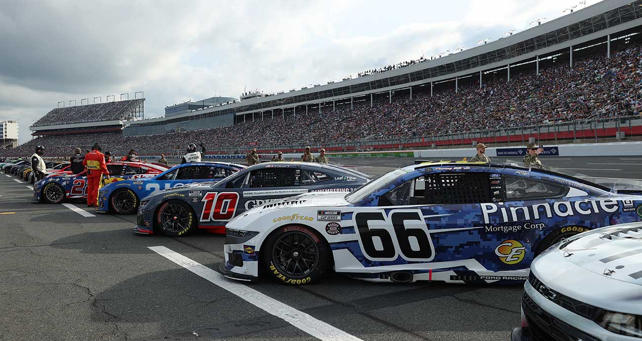 Cup Series cars sit lined up on pit road at Charlotte Motor Speedway