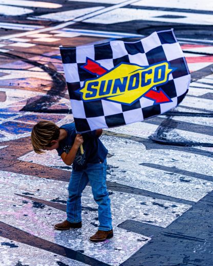 Brooks Briscoe poses for a photo with the checkered flag.