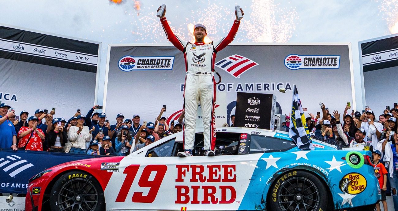 Chase Briscoe celebrates on top of car.