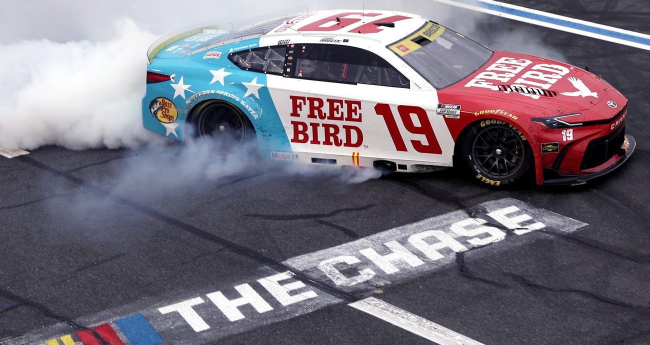 Chase Briscoe does a burnout in the No. 19 Free Bird Toyota near The Chase logo on the track at Charlotte Motor Speedway.