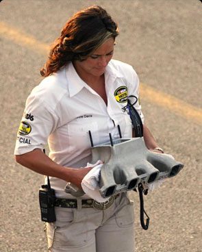 Brienne Davis inspects a race car part.