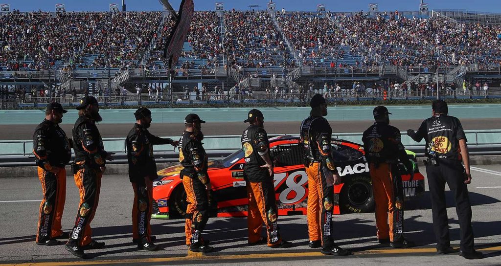 The Furniture Row No. 78 team salutes Martin Truex Jr. as he hits the track at Homestead-Miami Speedway