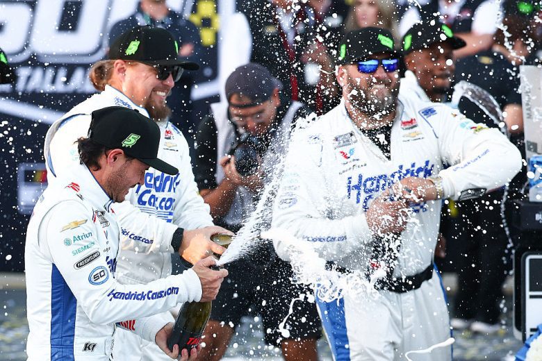 Kyle Larson and his pit crew spray champagne.
