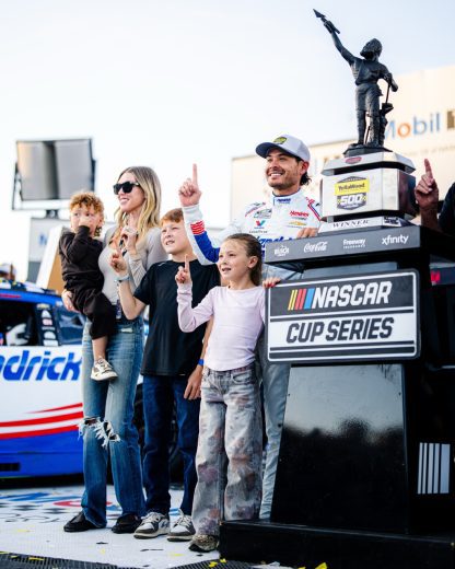 Kyle Larson and his family pose for a photo in Victory Lane.